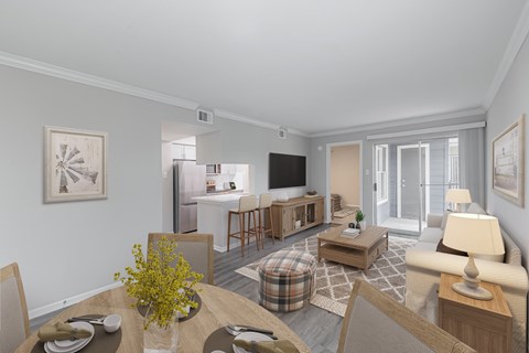 A well-lit living room with a dining table set for two.