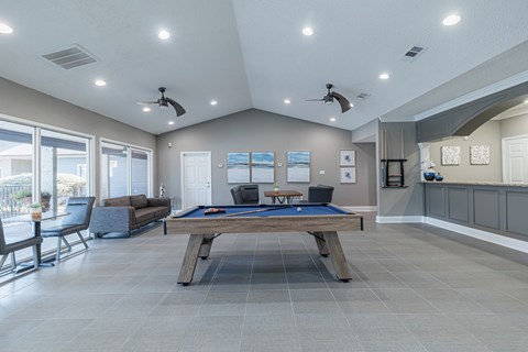 A room with a pool table and a couch.