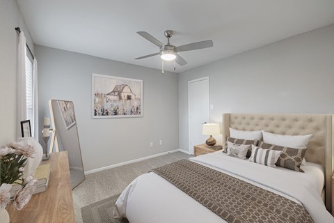 A bedroom with a large bed and a ceiling fan.