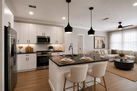 A modern kitchen with a black countertop and white cabinets.