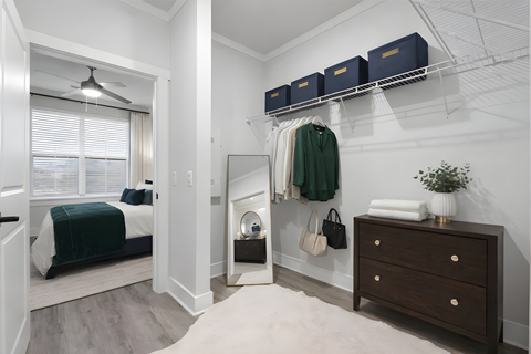 A bedroom with a bed, dresser, and a mirror.