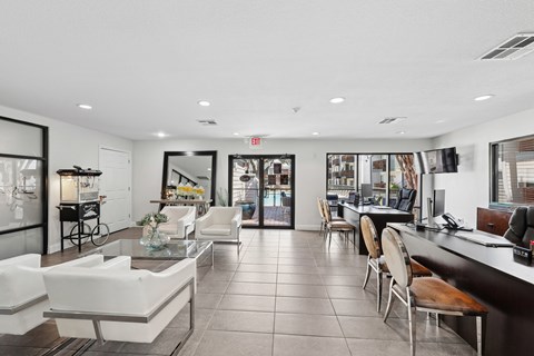 A spacious lobby with white furniture and a reception desk.