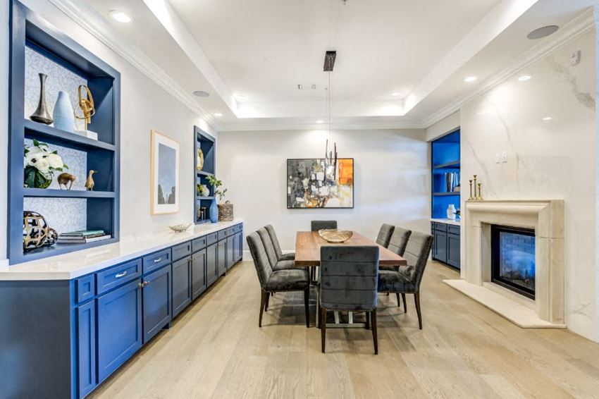a dining room with blue cabinets and a table and chairs and a fireplace