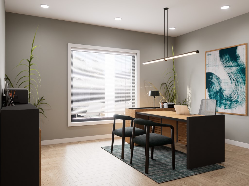 A modern office with a wooden desk and black chairs.