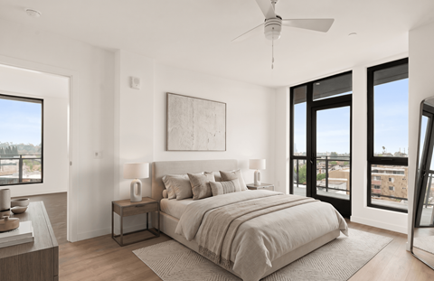 A bedroom with a large bed and a ceiling fan.
