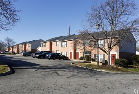 A street view of a residential area with houses and cars.