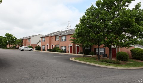 A street view of a residential area with houses and a car.