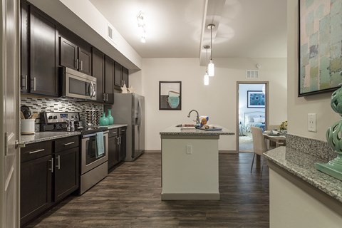 A kitchen with dark wood cabinets and a white island.
