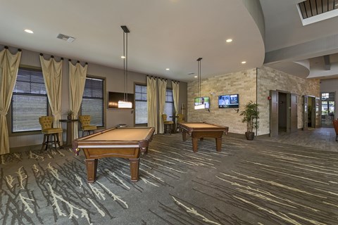 A room with a pool table and a television.
