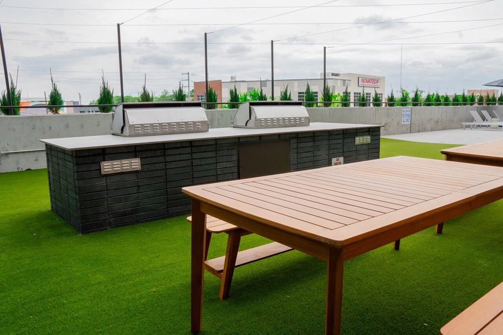a picnic table and barbecue grill on the roof of a building