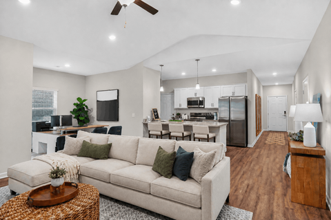 A modern living room with a white couch and a wooden coffee table.