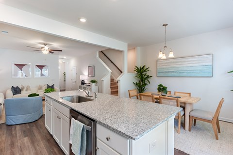 A kitchen with a granite countertop and a dining table with chairs.