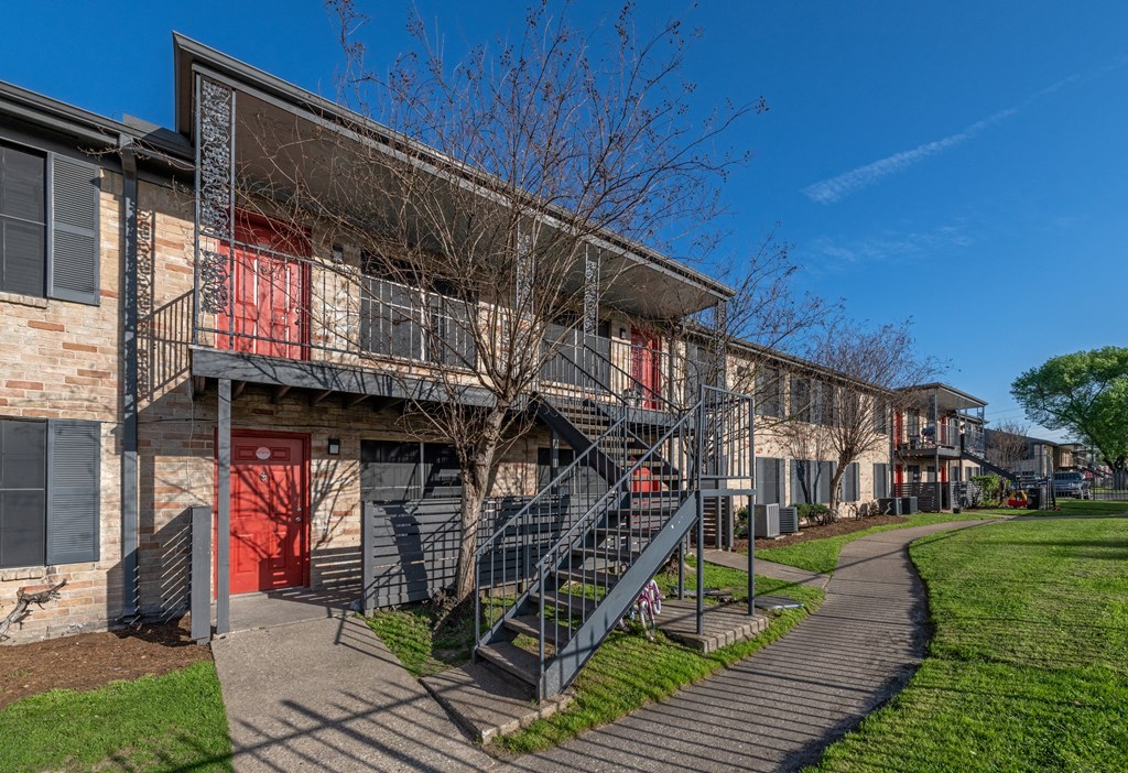 exterior photo of two story apartment building with stairs