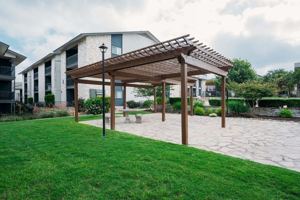 a patio with a pergola in front of a building