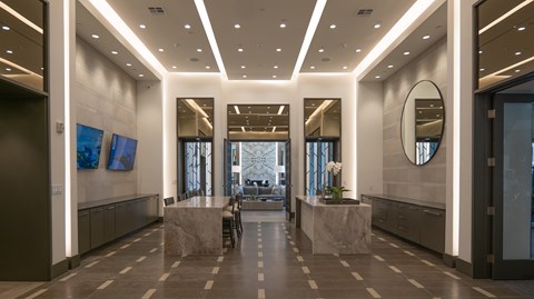 A hallway with a marble floor and a large mirror on the wall.