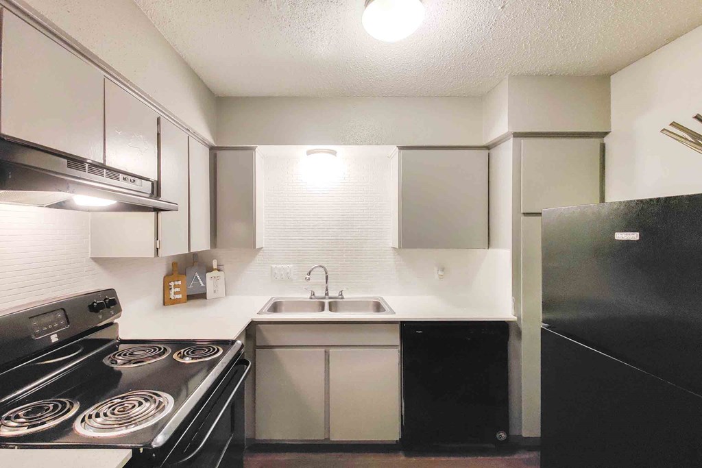 a kitchen with white cabinets and black appliances