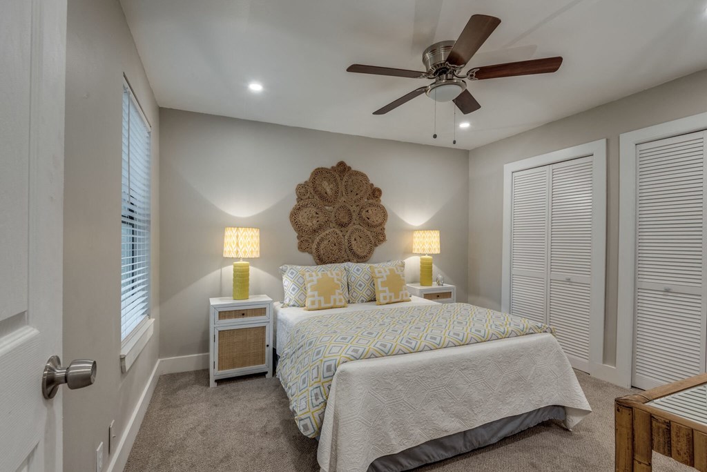 a bedroom with a large bed and a ceiling fan