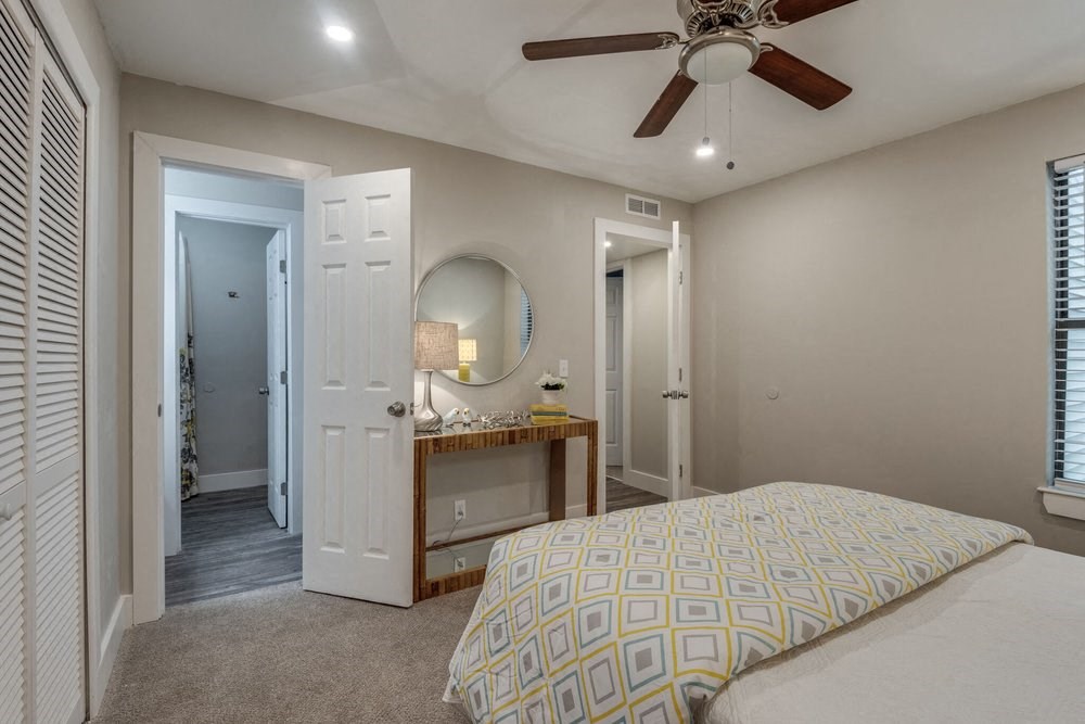 a bedroom with a bed and a ceiling fan