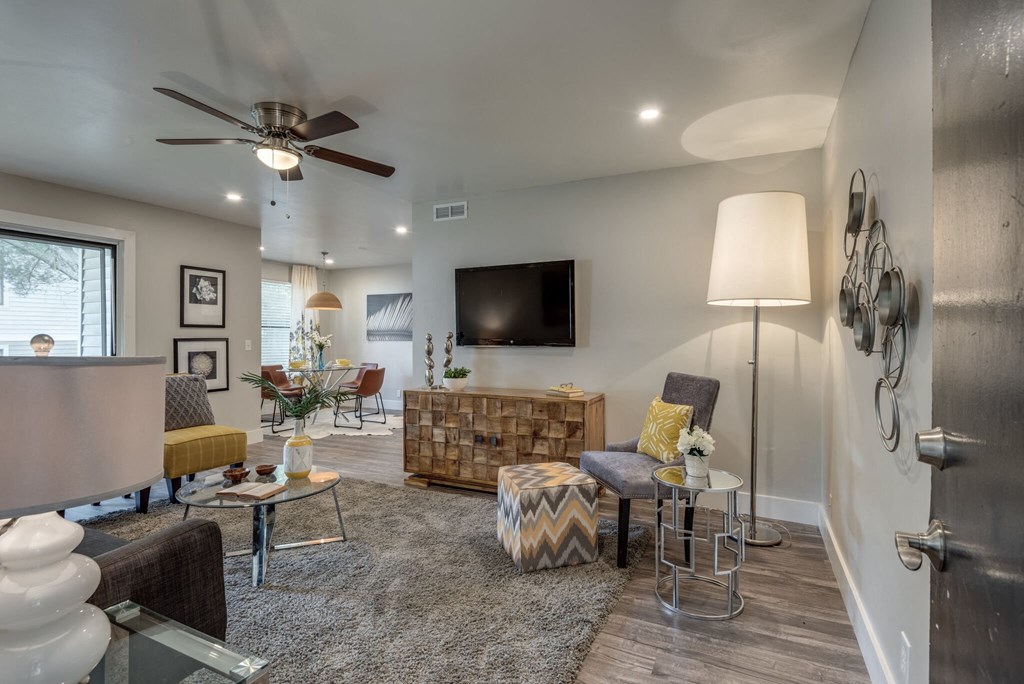 a living room with a ceiling fan and a tv