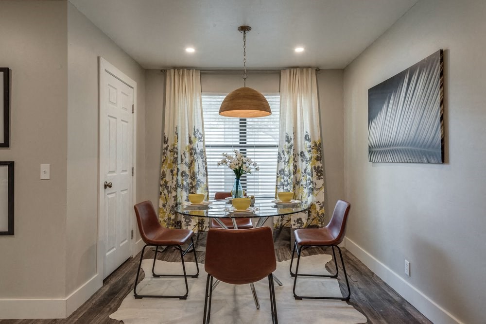 a dining room with a table and chairs in front of a window
