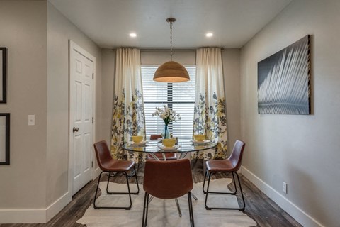 a dining room with a table and chairs in front of a window