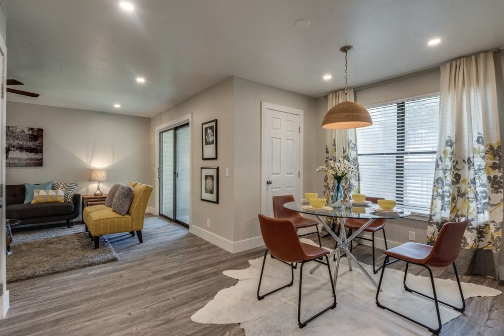 a dining room and living room with a table and chairs