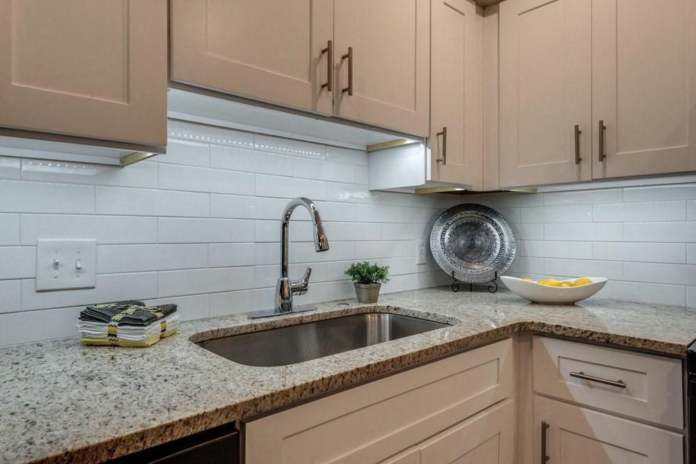 a kitchen with a sink and white cabinets