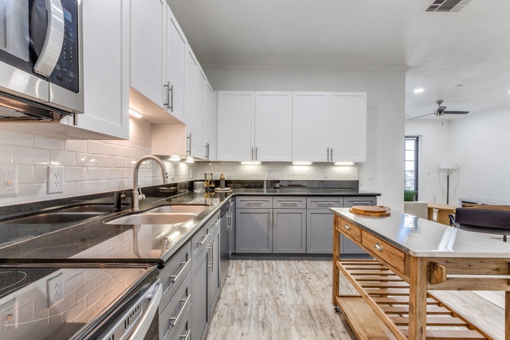 a large kitchen with stainless steel counter tops and white cabinets