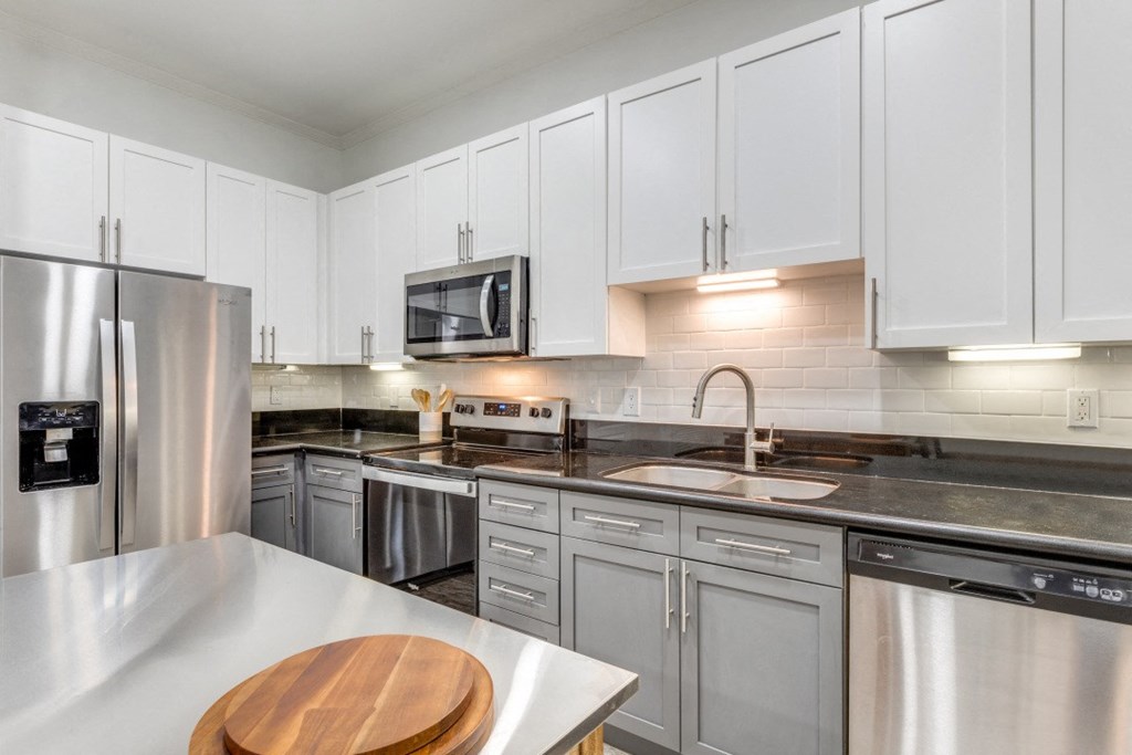 a modern kitchen with stainless steel appliances and white cabinets