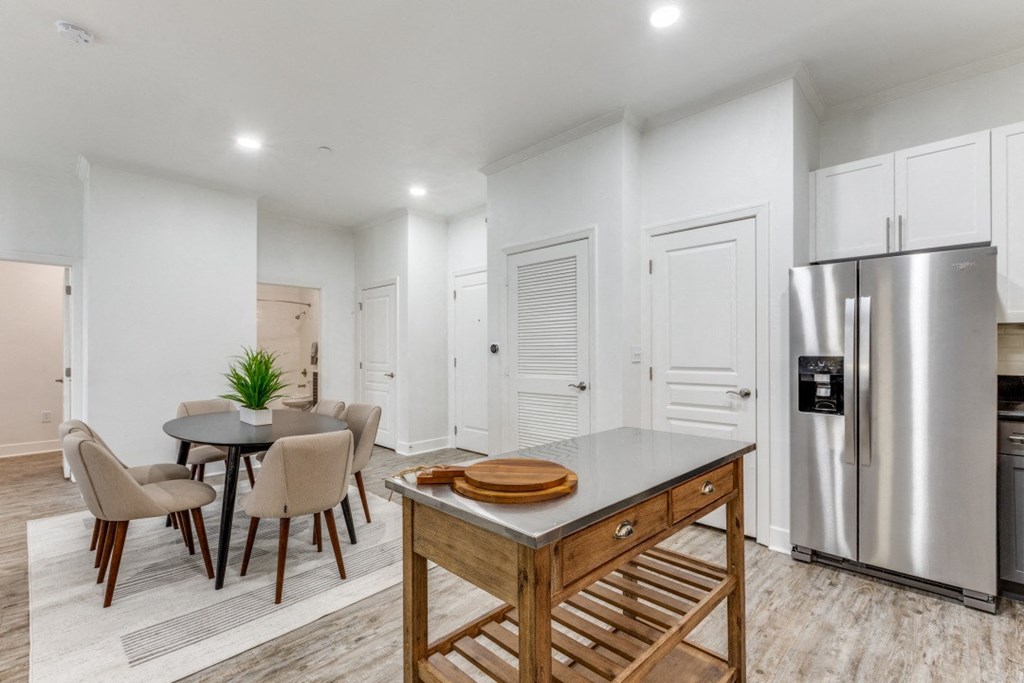 a kitchen with a table and chairs and a refrigerator