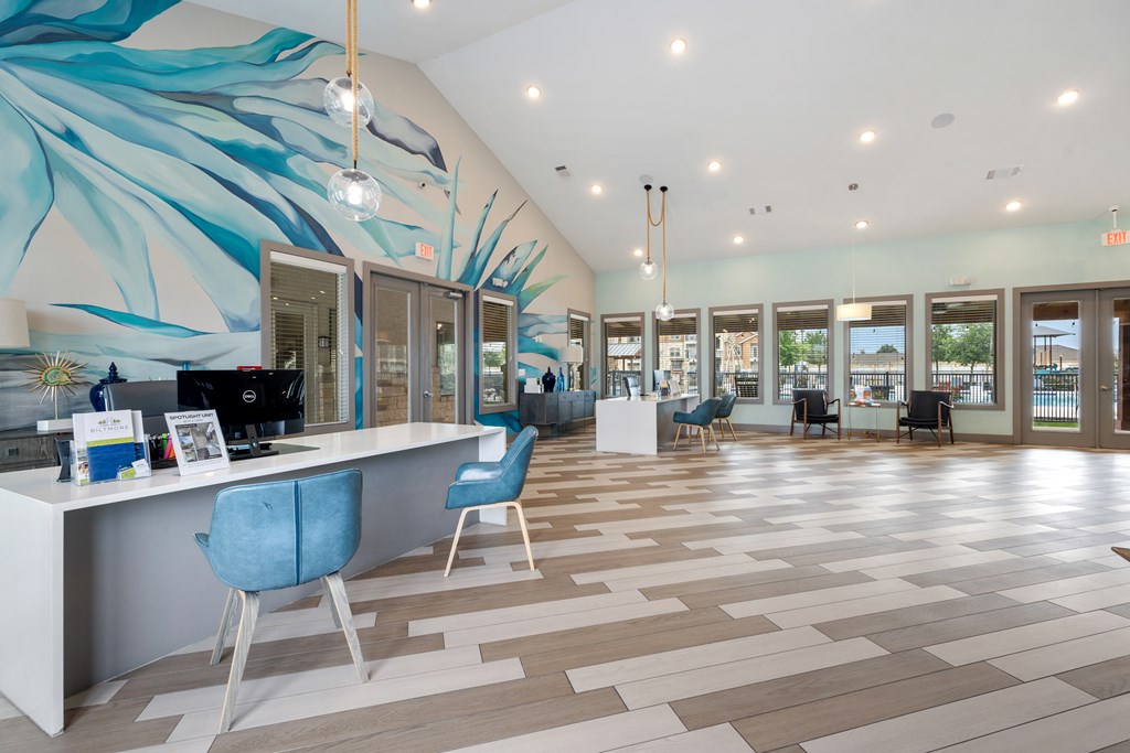 A reception area with a blue chair and a white desk.