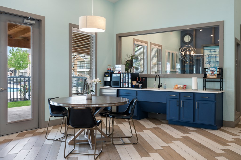 A kitchen with a table and chairs in front of a window.