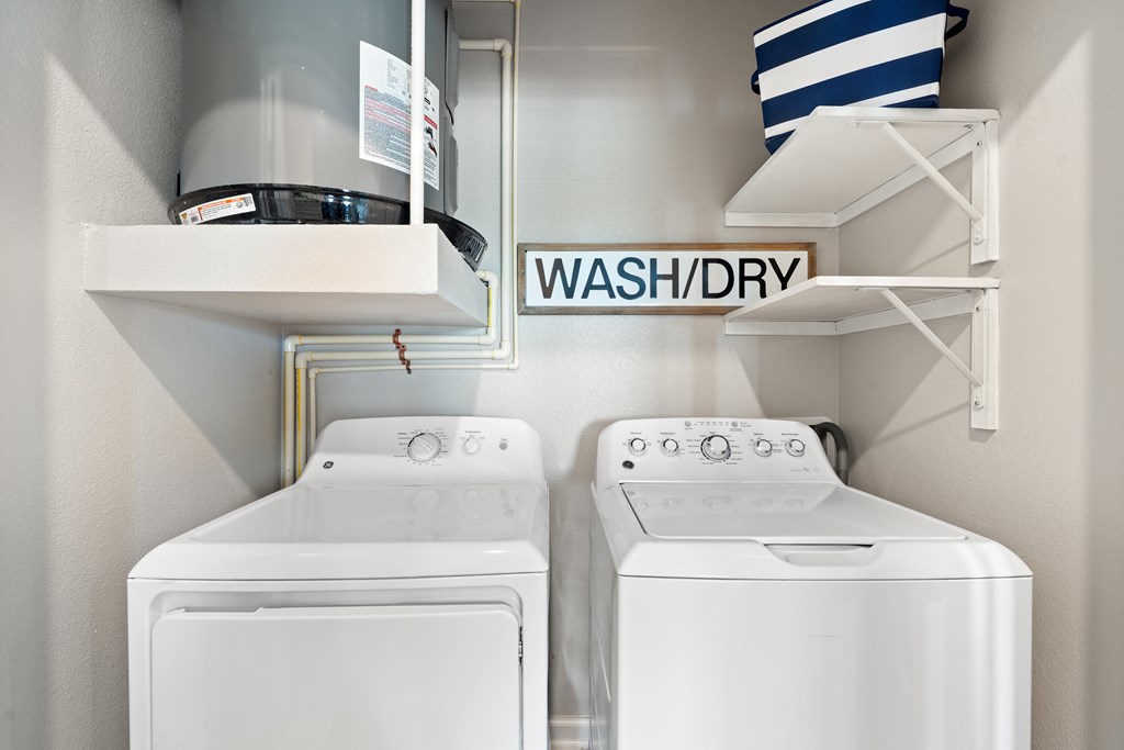 Two white washing machines in a laundry room.