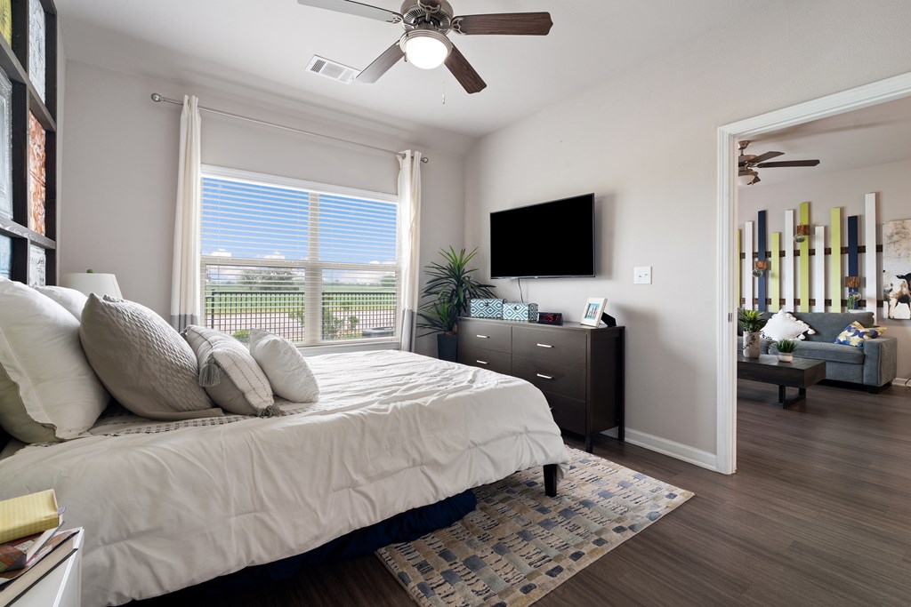 A bedroom with a large bed and a flat screen TV mounted on the wall.