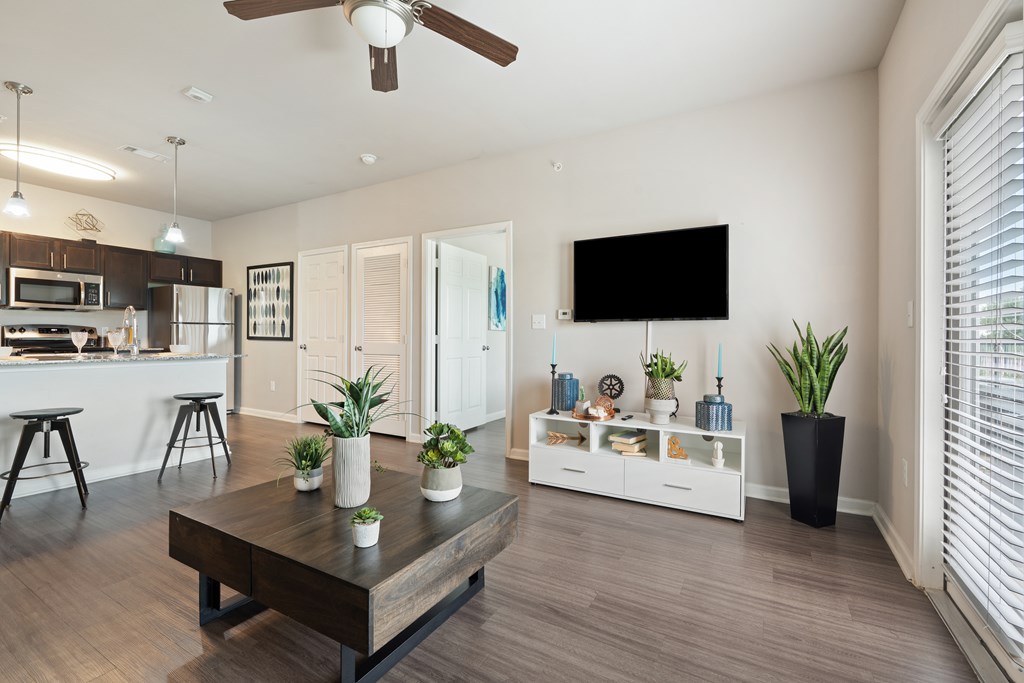 A modern living room with a wooden coffee table and a flat screen TV mounted on the wall.