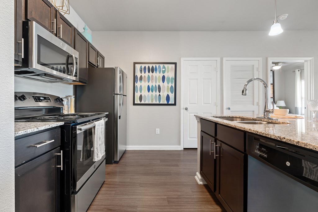 A kitchen with black appliances and wooden cabinets.
