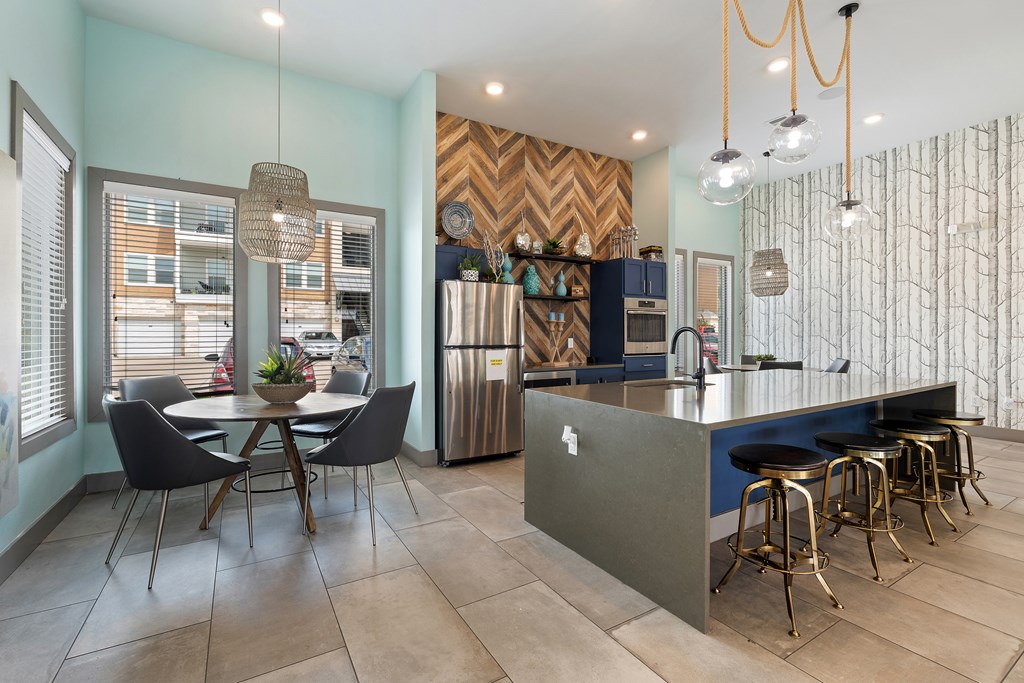 A kitchen with a dining table and chairs.