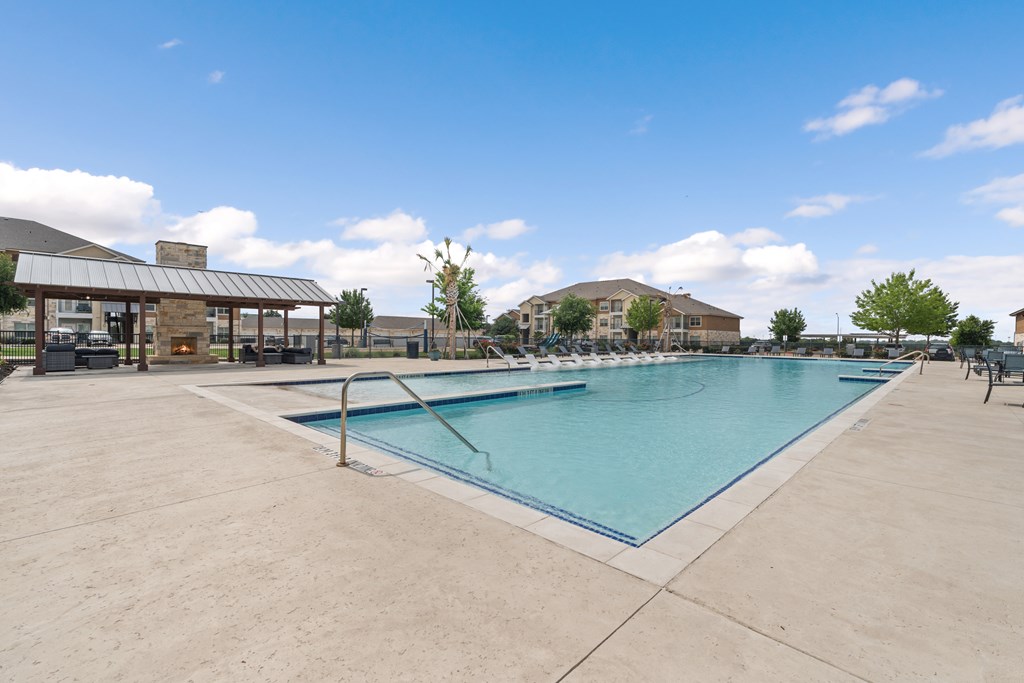 A large outdoor swimming pool with a building in the background.