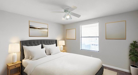 A bedroom with a large bed and a ceiling fan.