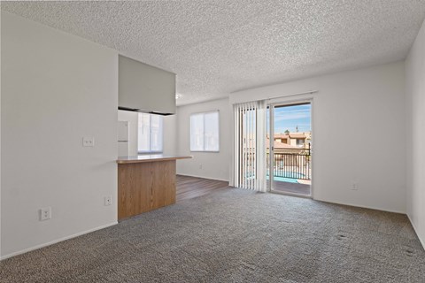 A room with a carpeted floor and a balcony with a railing.