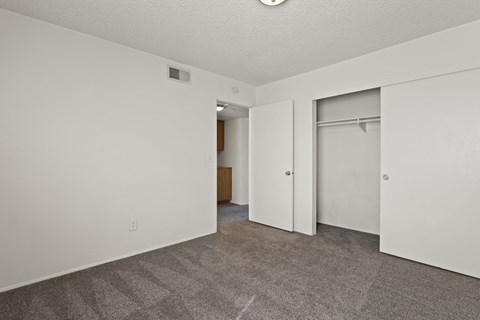 A room with a carpeted floor and a white door.