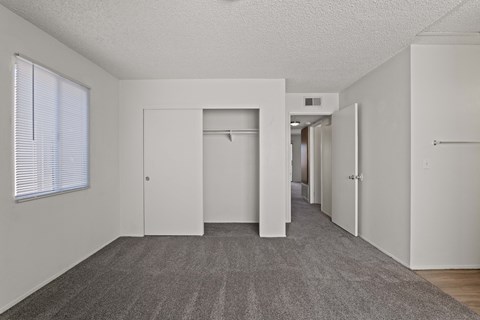 A long hallway with white doors and a carpeted floor.
