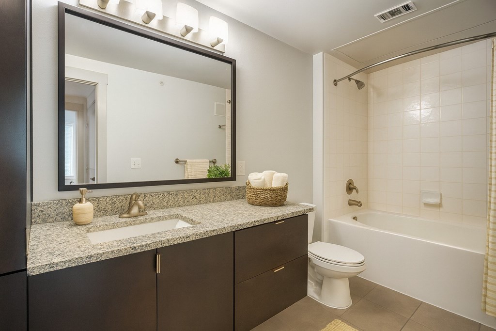 A bathroom with a white toilet and a white bathtub.