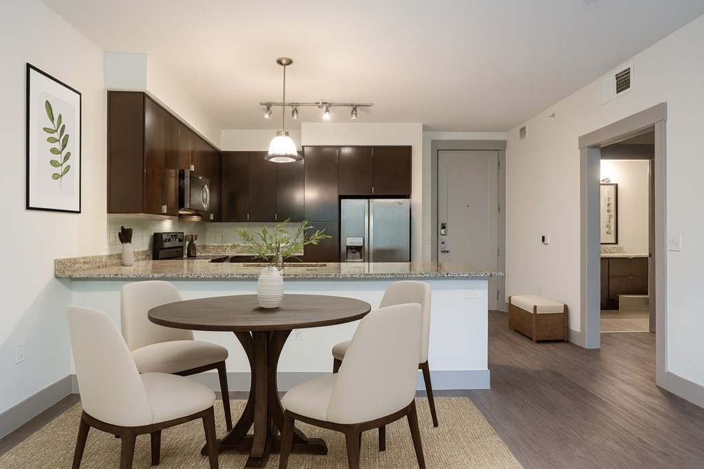 A modern kitchen with a round table and chairs.