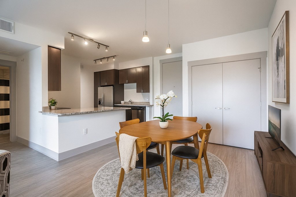 A modern dining room with a wooden table and chairs.