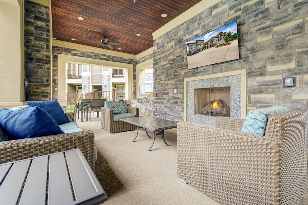 Outdoor lounge area with covered patio, fireplace and wicker furniture