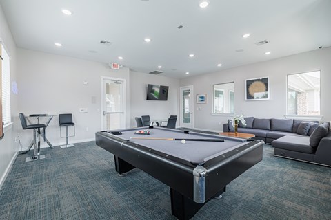 A room with a pool table and a couch.