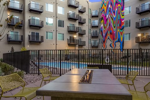 A colorful mural on a building behind a pool.