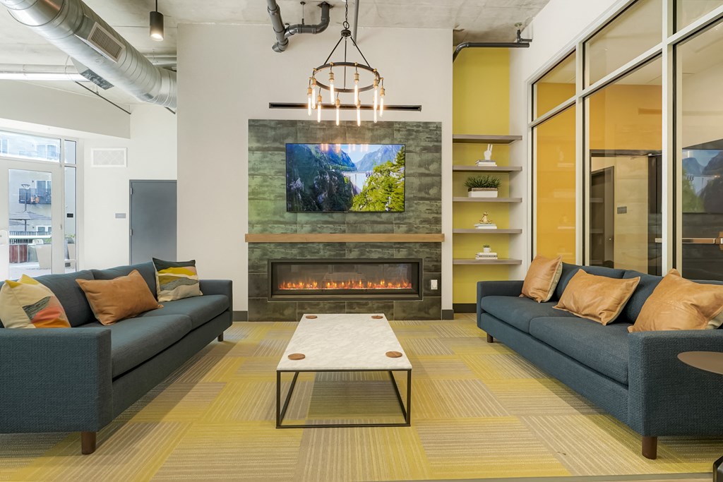 A modern living room with a fireplace and a television mounted above it.
