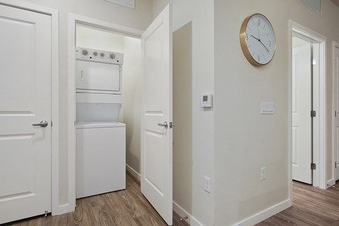 A kitchen with a white oven and a clock on the wall.